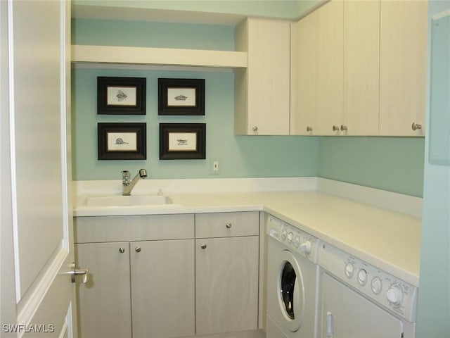 laundry room with washer and dryer, sink, and cabinets