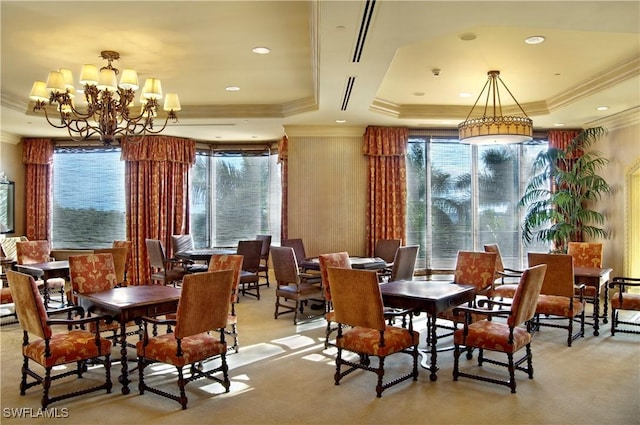 dining area featuring a chandelier, a tray ceiling, and ornamental molding