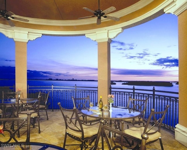 patio terrace at dusk with ceiling fan and a water view