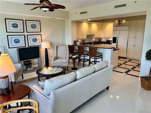 living room with ceiling fan with notable chandelier