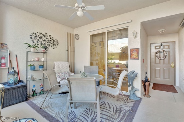 interior space with ceiling fan, light tile patterned floors, and a textured ceiling