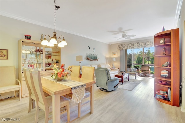 dining space featuring light hardwood / wood-style floors, ceiling fan with notable chandelier, and ornamental molding