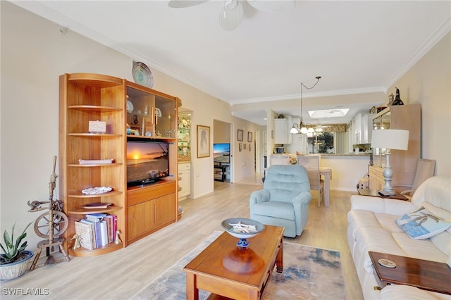 living room featuring ceiling fan with notable chandelier, light hardwood / wood-style floors, and ornamental molding