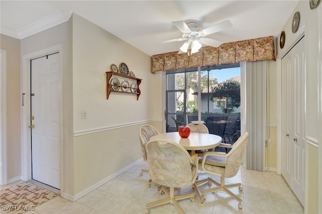 tiled dining area with ceiling fan and ornamental molding