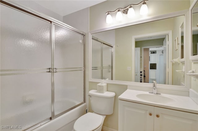 full bathroom featuring vanity, toilet, and bath / shower combo with glass door