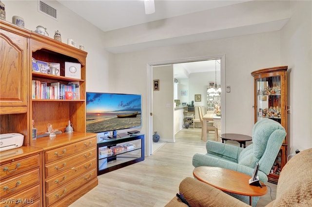 sitting room with ornamental molding and light wood-type flooring