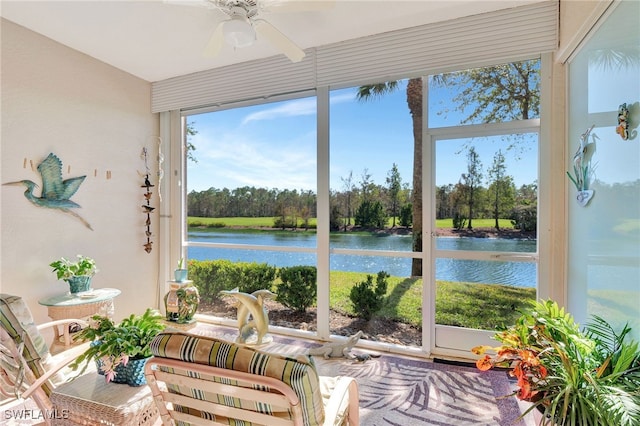 sunroom / solarium featuring ceiling fan and a water view