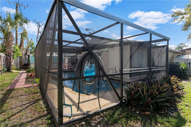 view of home's exterior with glass enclosure