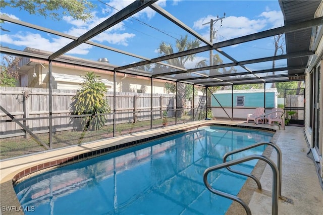 view of swimming pool featuring a lanai