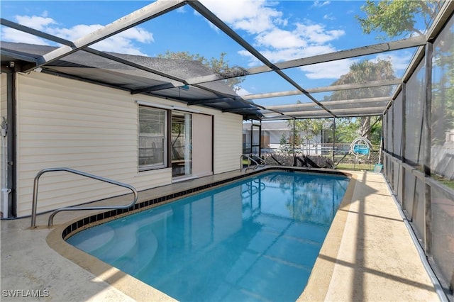 view of pool featuring glass enclosure and a patio area