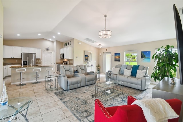 living room featuring a chandelier, light tile patterned floors, sink, and vaulted ceiling