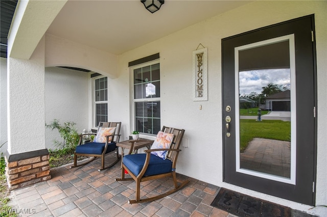 view of exterior entry featuring covered porch