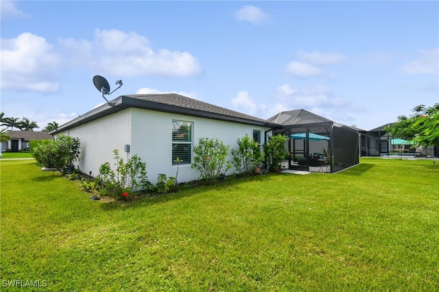 back of house featuring glass enclosure and a lawn