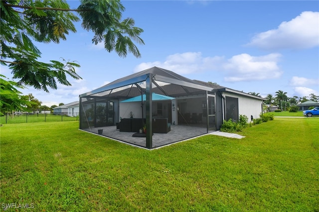 back of property featuring a yard, a patio, and a lanai