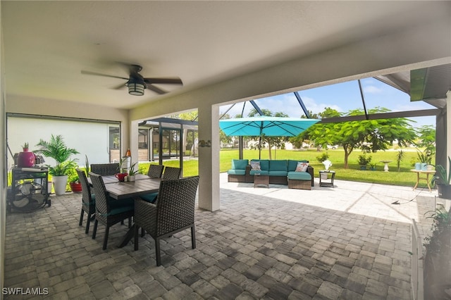 view of patio with glass enclosure, ceiling fan, and an outdoor living space