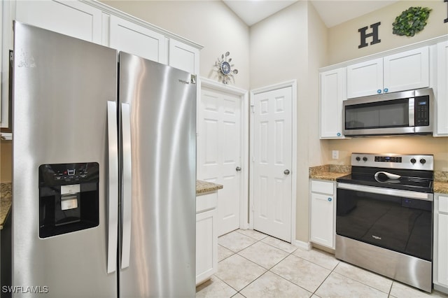 kitchen featuring light stone counters, white cabinetry, stainless steel appliances, and light tile patterned floors