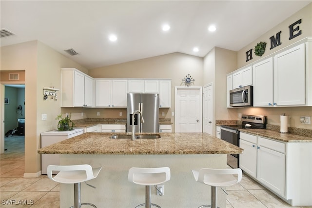 kitchen featuring white cabinets, sink, appliances with stainless steel finishes, and vaulted ceiling