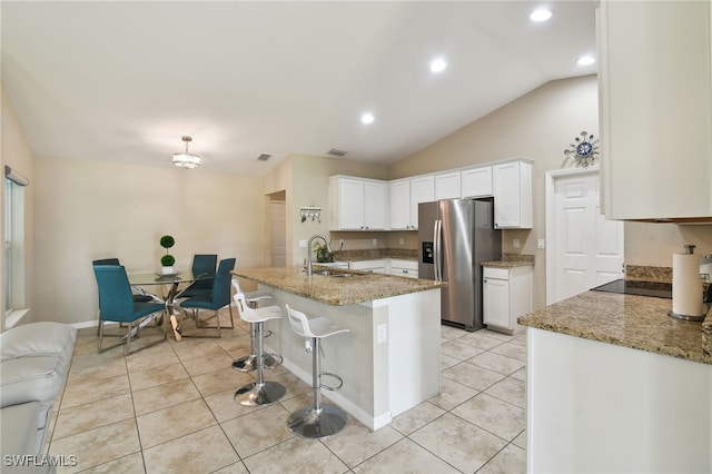 kitchen featuring lofted ceiling, white cabinetry, stainless steel fridge with ice dispenser, and sink