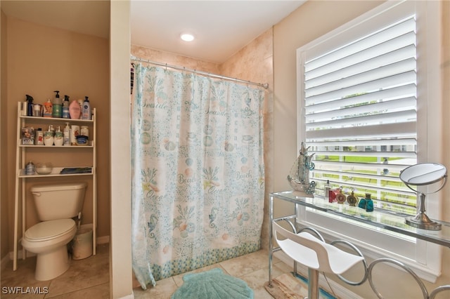 bathroom with tile patterned flooring, toilet, and walk in shower