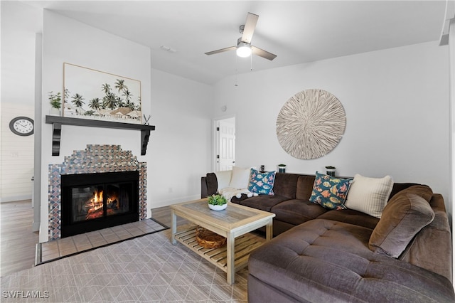 living room with ceiling fan, light hardwood / wood-style floors, and a fireplace