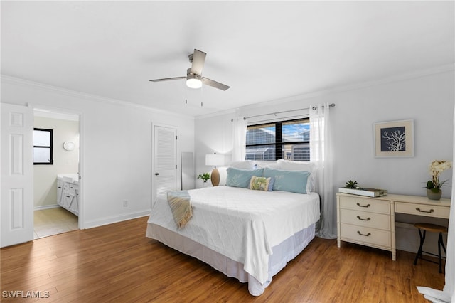 bedroom featuring hardwood / wood-style flooring, ensuite bath, multiple windows, and ceiling fan