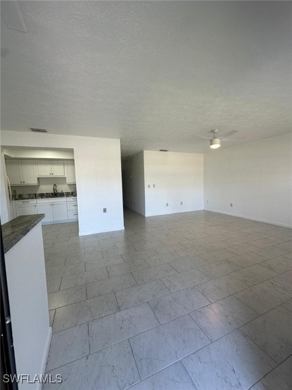 spare room with ceiling fan and a textured ceiling