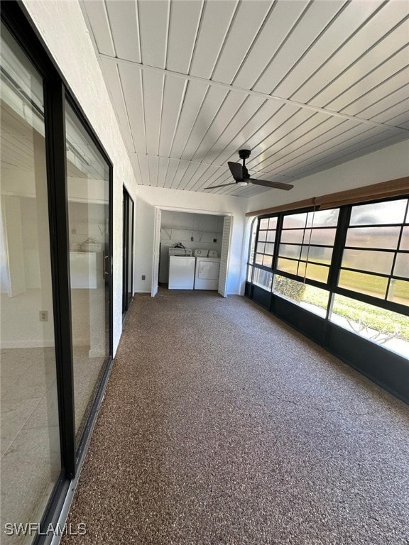 unfurnished sunroom featuring ceiling fan and independent washer and dryer