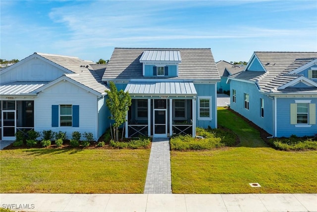 bungalow-style home with a front lawn and a sunroom