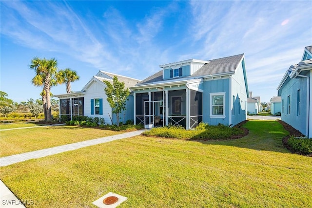 view of front of property featuring a sunroom and a front yard