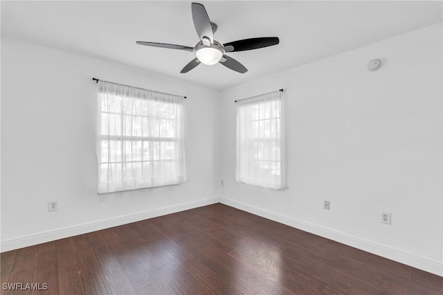 empty room with ceiling fan and dark hardwood / wood-style flooring