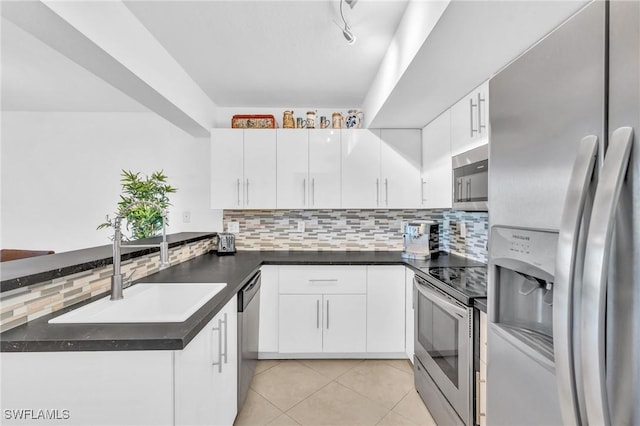 kitchen featuring kitchen peninsula, appliances with stainless steel finishes, white cabinetry, and sink