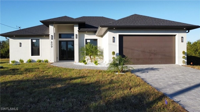 prairie-style house featuring a garage and a front yard