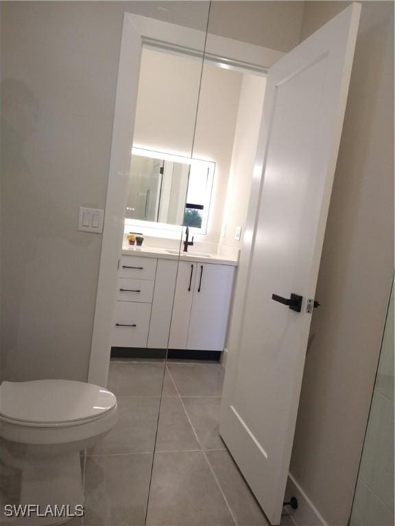 bathroom featuring tile patterned floors, vanity, and toilet