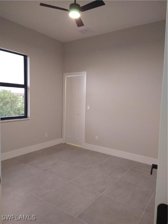 tiled empty room with ceiling fan