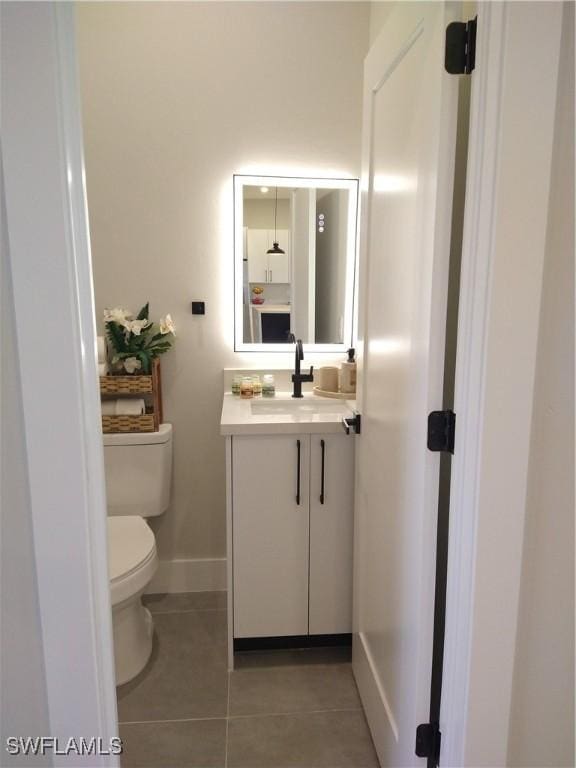 bathroom featuring toilet, vanity, and tile patterned floors