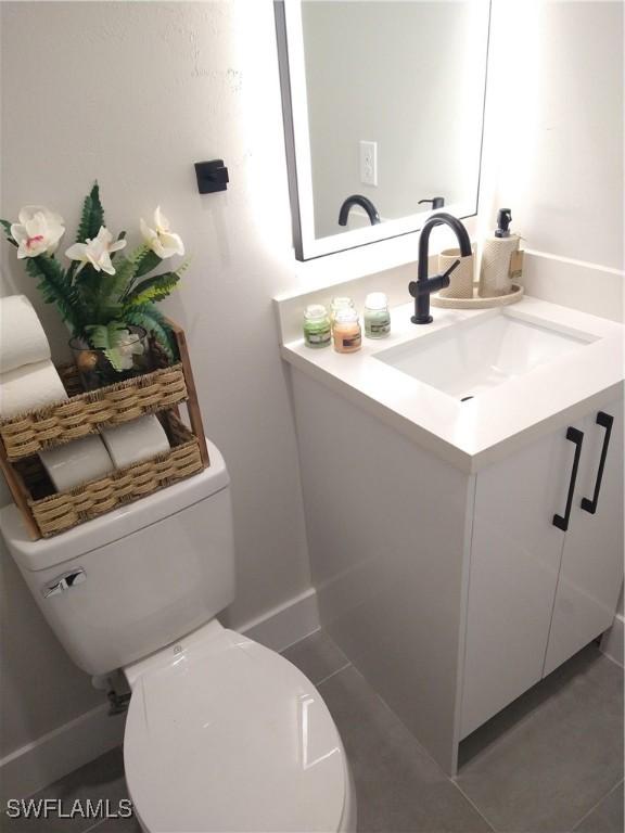 bathroom with tile patterned flooring, vanity, and toilet