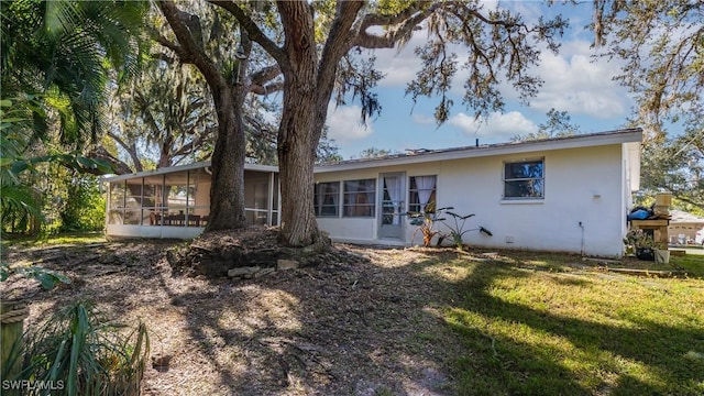 back of property featuring a sunroom and a yard