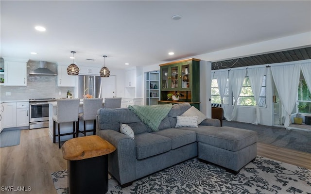 living room with beamed ceiling and light wood-type flooring