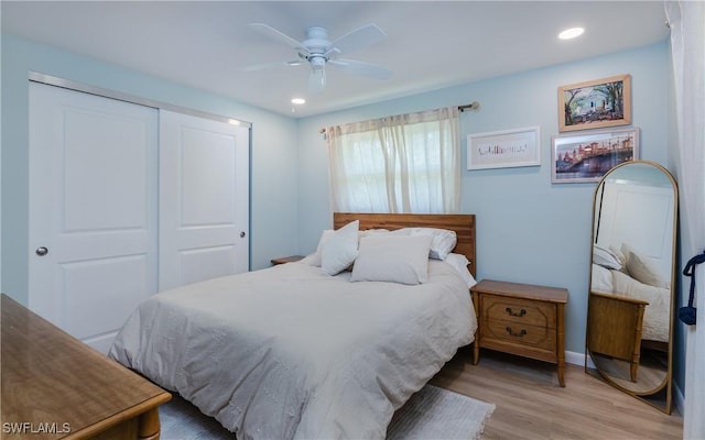 bedroom with light hardwood / wood-style floors, a closet, and ceiling fan