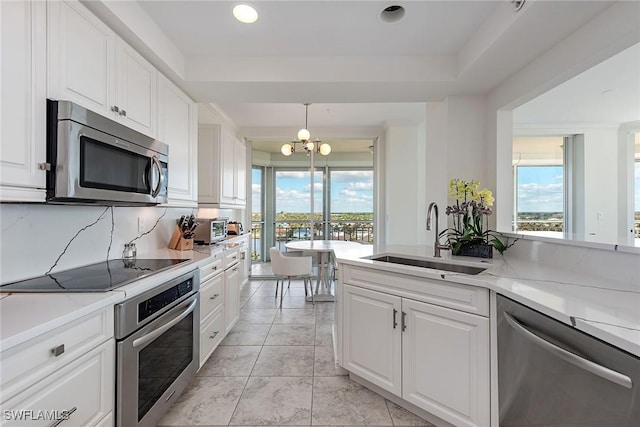 kitchen with sink, white cabinetry, stainless steel appliances, and tasteful backsplash