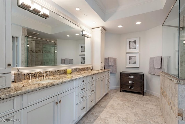 bathroom featuring a raised ceiling, vanity, an enclosed shower, and ornamental molding