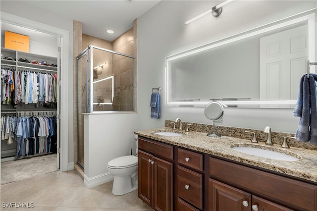 bathroom with vanity, toilet, tile patterned floors, and walk in shower