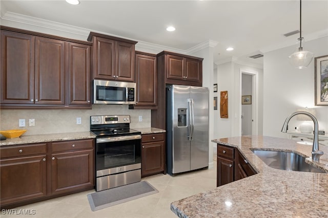 kitchen with sink, dark brown cabinets, light stone countertops, and appliances with stainless steel finishes