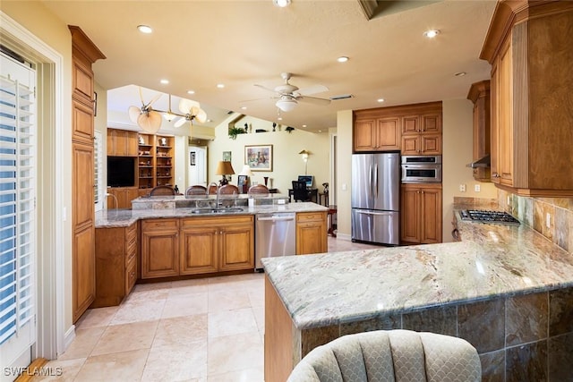 kitchen with appliances with stainless steel finishes, kitchen peninsula, and sink