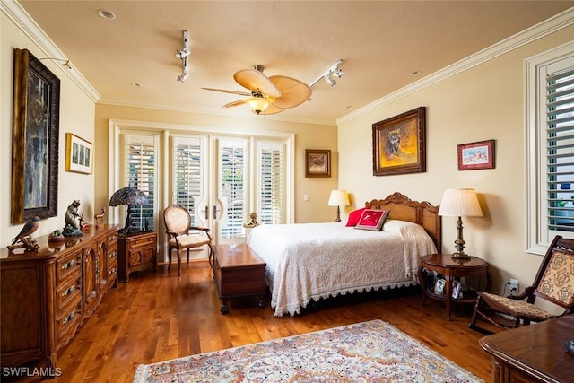 bedroom with ornamental molding, dark hardwood / wood-style floors, track lighting, and ceiling fan