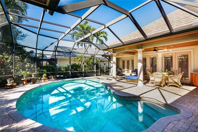 view of pool with a patio, ceiling fan, glass enclosure, and french doors