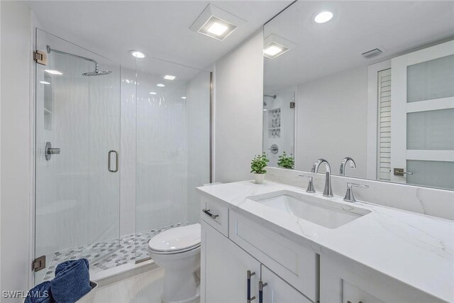 bathroom with vanity, an enclosed shower, and toilet