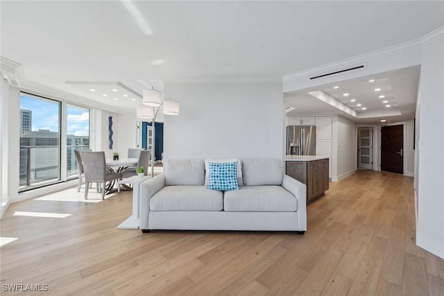 living room featuring crown molding and light hardwood / wood-style floors