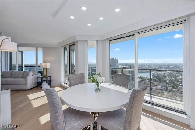 dining space featuring ornamental molding, plenty of natural light, and light hardwood / wood-style floors