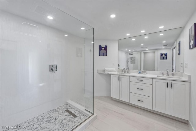 bathroom with tiled shower and vanity